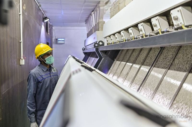Factory worker monitoring industrial textile machinery