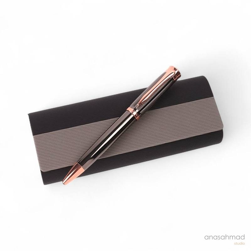 Rose gold and black textured ballpoint pen styled on a black and grey gift box