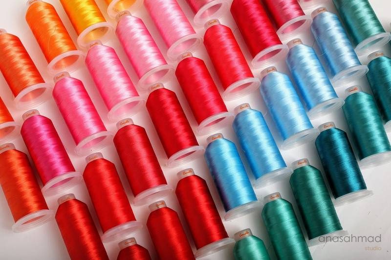 Rows of colorful embroidery thread spools in a gradient of colors — Anas Ahmad Studio, Karachi