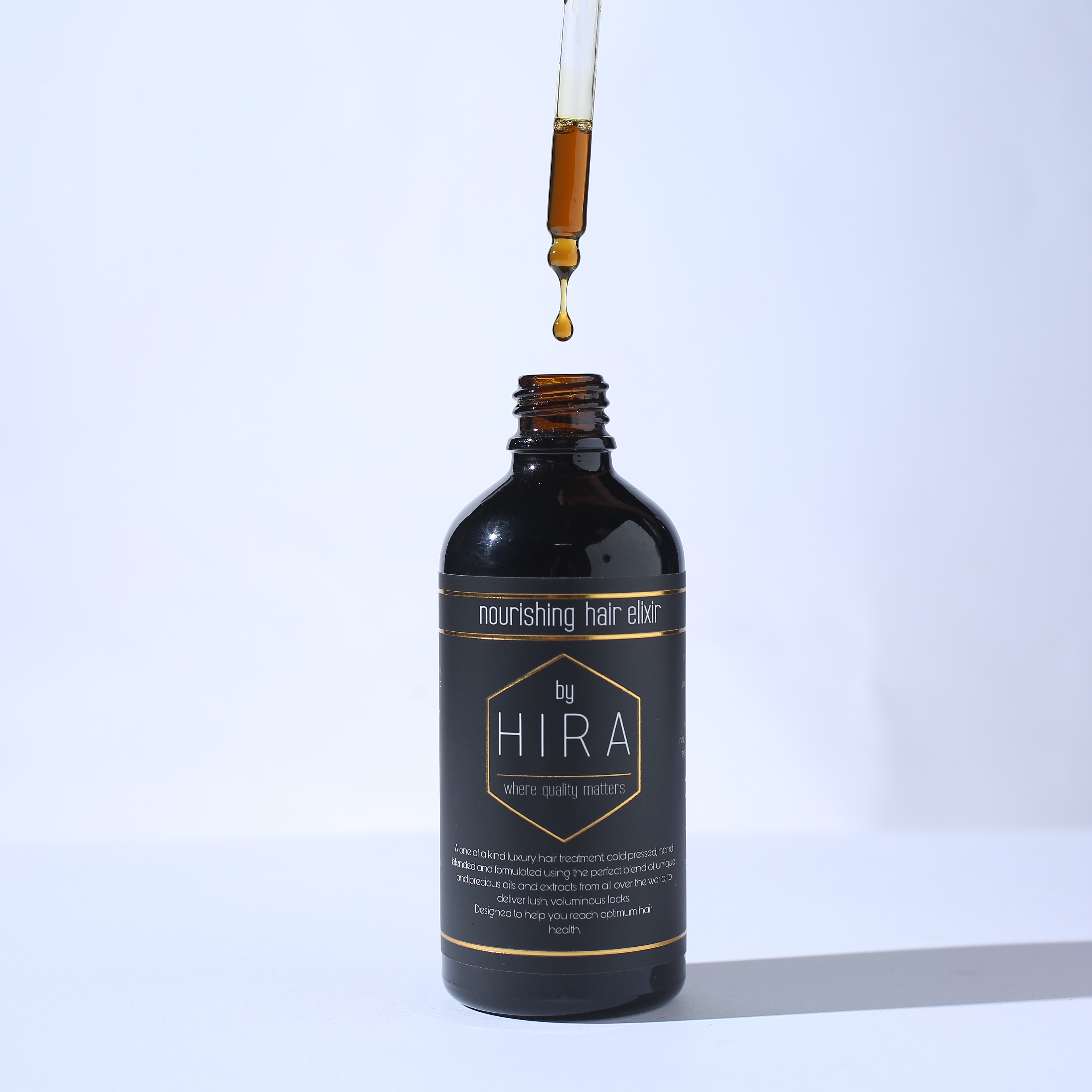 Premium nourishing hair oil bottle with dropper on clean background